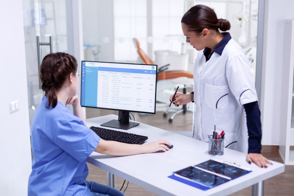 Show a comparison table on a laptop in a dental practice office