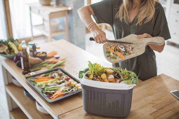 "A woman holding a container of spoiled leftovers, looking disappointed."
