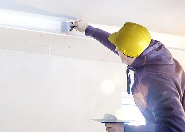 “Professional plastering service Auckland team smoothing residential walls”