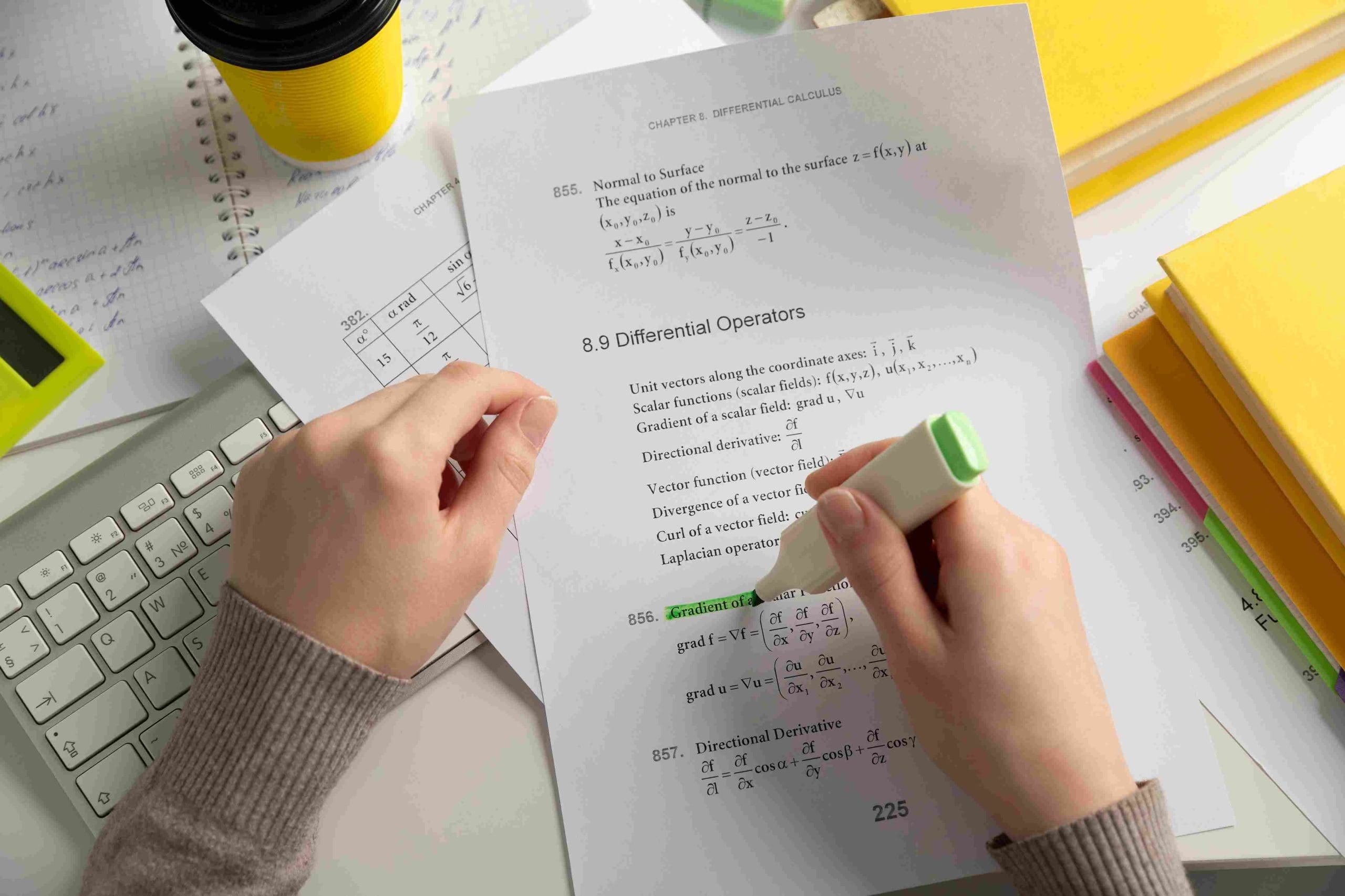 Student highlighting differential calculus notes, relevant for GCSE paper formats.