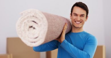 happy-male-carrying-carpet-new-home_329181-12615