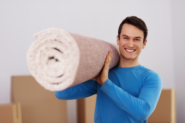 happy-male-carrying-carpet-new-home_329181-12615