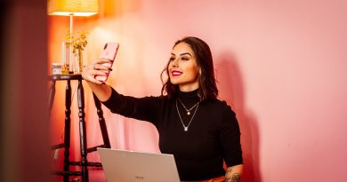 woman taking selfie in pink room with laptop